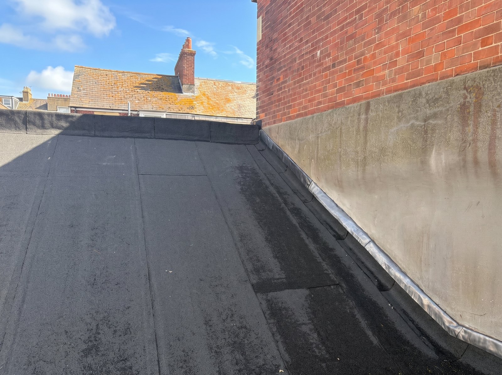 Fresh lead flashing dressed in against the rendered wall