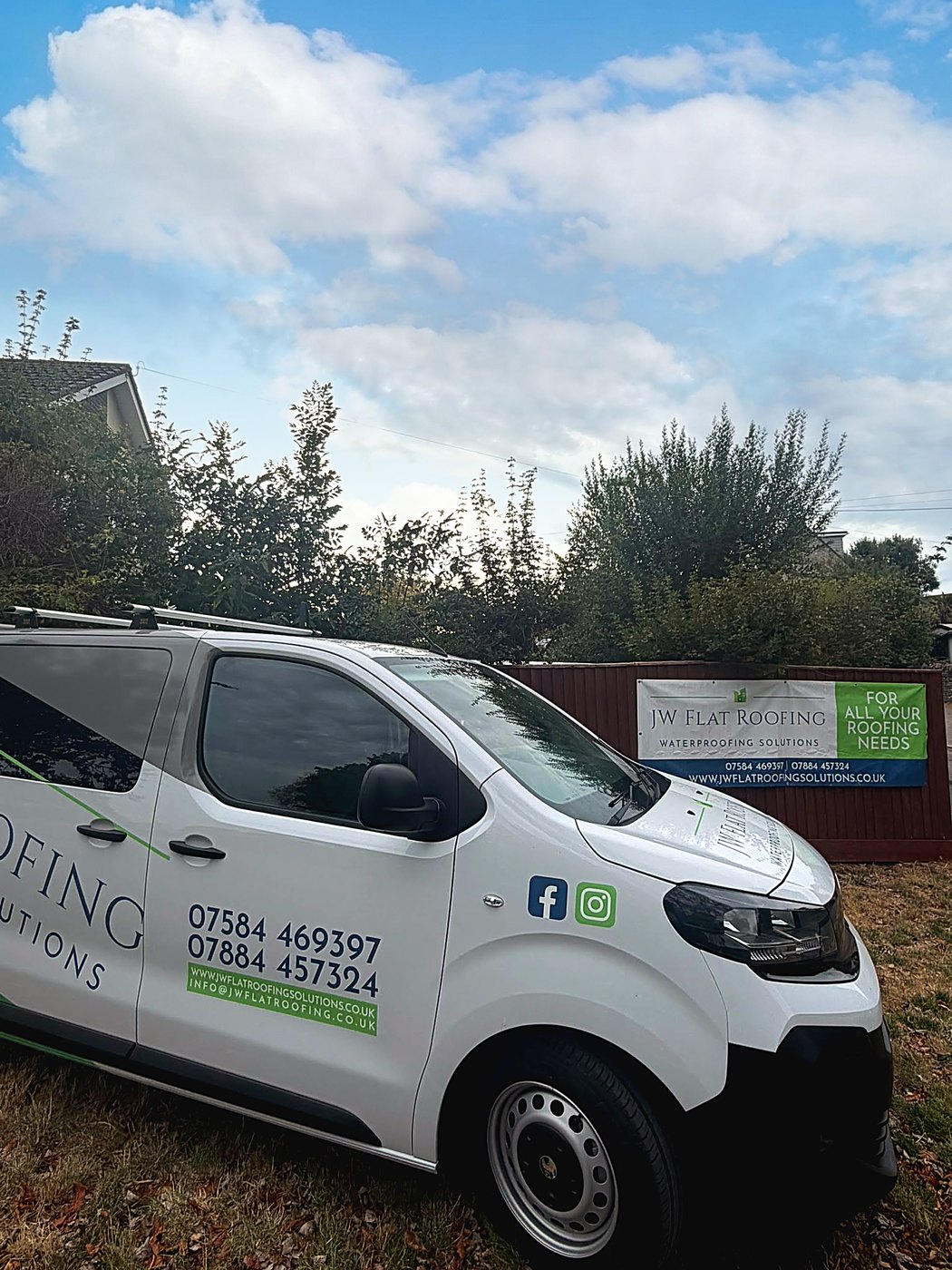 The JW Flat Roofing van and branded banner on site in Dorset, showing 07584 469397 and jwflatroofingsolutions.co.uk